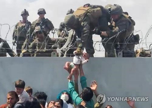 카불공항에서 미군이 아프간인의 간절한 요청에 아기만 구조하는 모습. 제3자제공. 재판매 및 DB 금지. [로이터=연합뉴스]
